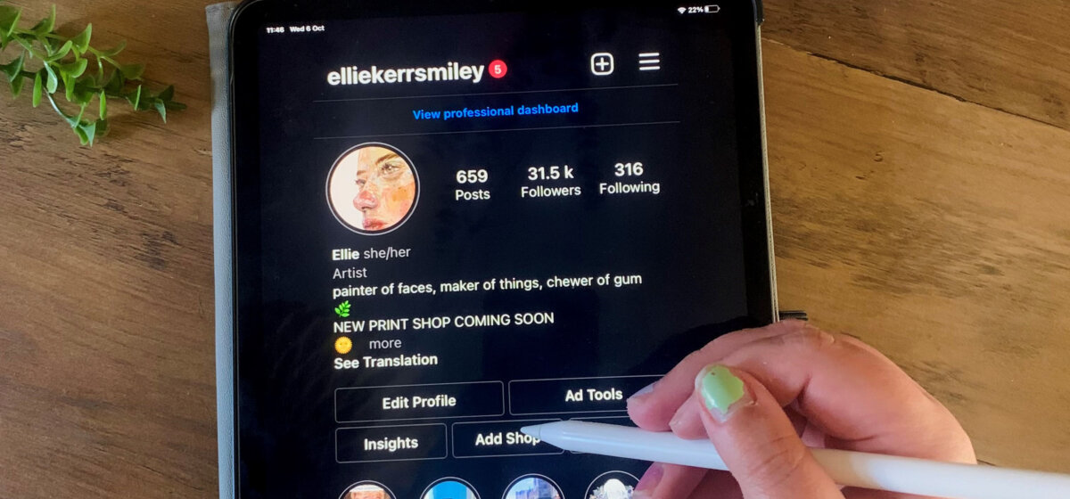 Ipad screen open on an instagram page with hand holding i-pen above it.