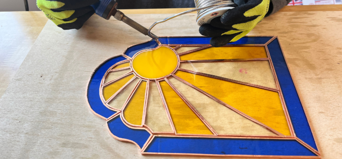 A yellow sun glass mosaic with a blue outline