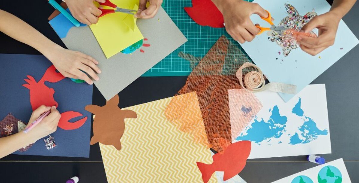 An image for Half Term Art Club at The Base, Greenham. Pictured is a selection of colour paper that children are cutting shapes out of.