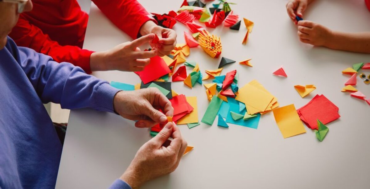 An image for The Base's world craft inspired portraits of children cutting up pieces of paper for their collage